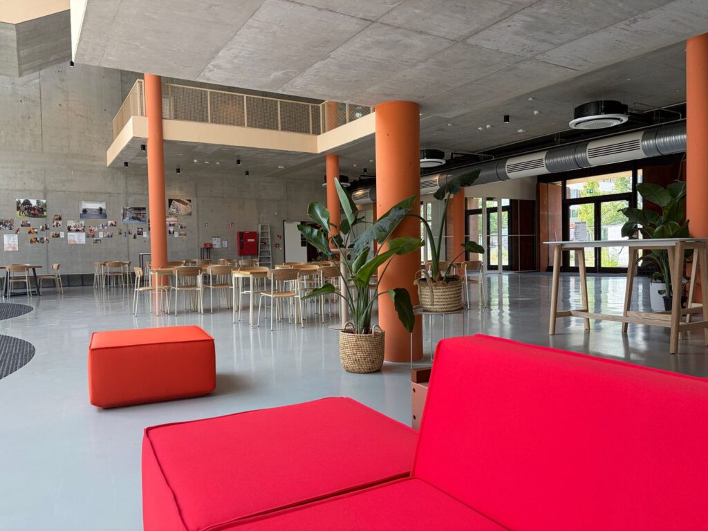 Innenraum im Kreativ Quartier Potsdam mit offenem Aufenthaltsbereich, Designmöbeln und moderner Architektur.